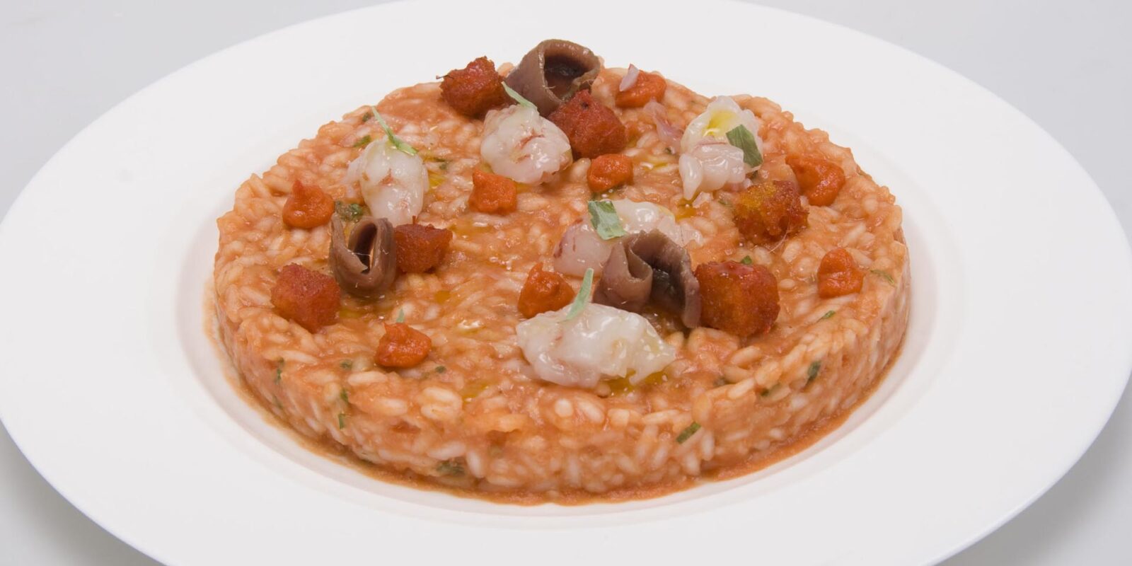 Risotto al pomodoro San Marzano con tartare di gamberi e acciughe del